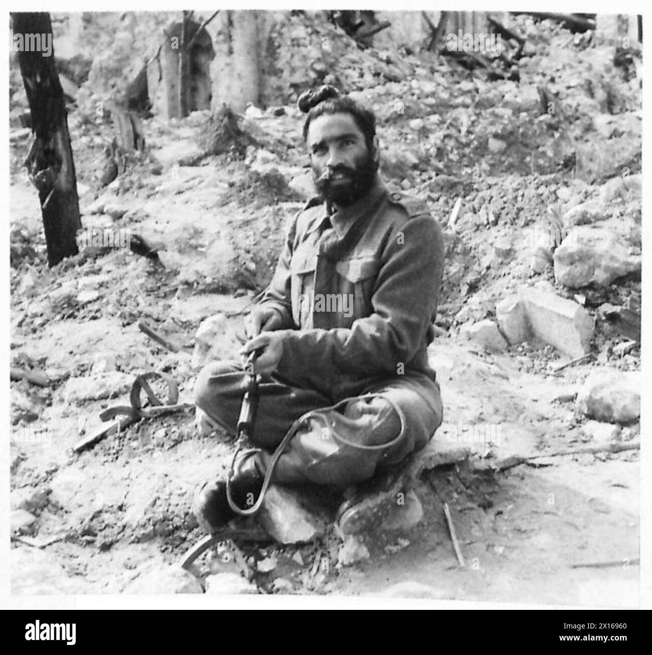 ITALIEN : FÜNFTE ARMYBRITISH INDISCHE PROVOST-FIRMA - L/Nayak Tara Singh, ein Sikh aus dem Punjab, mit Haaren in englischer "Bun"-Mode, reinigt seine Pistole britische Armee Stockfoto