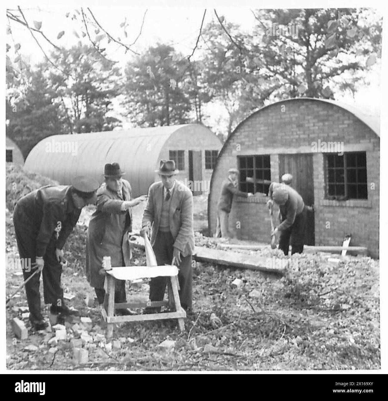 Garrison Engineer Lt. G. Holloway, Contractors Agent J.J. Jarvis und General Foreman Mr. J.J. Panphilon studieren Pläne für die Zuweisung und Einrichtung eines neuen Armeelagers. Stockfoto