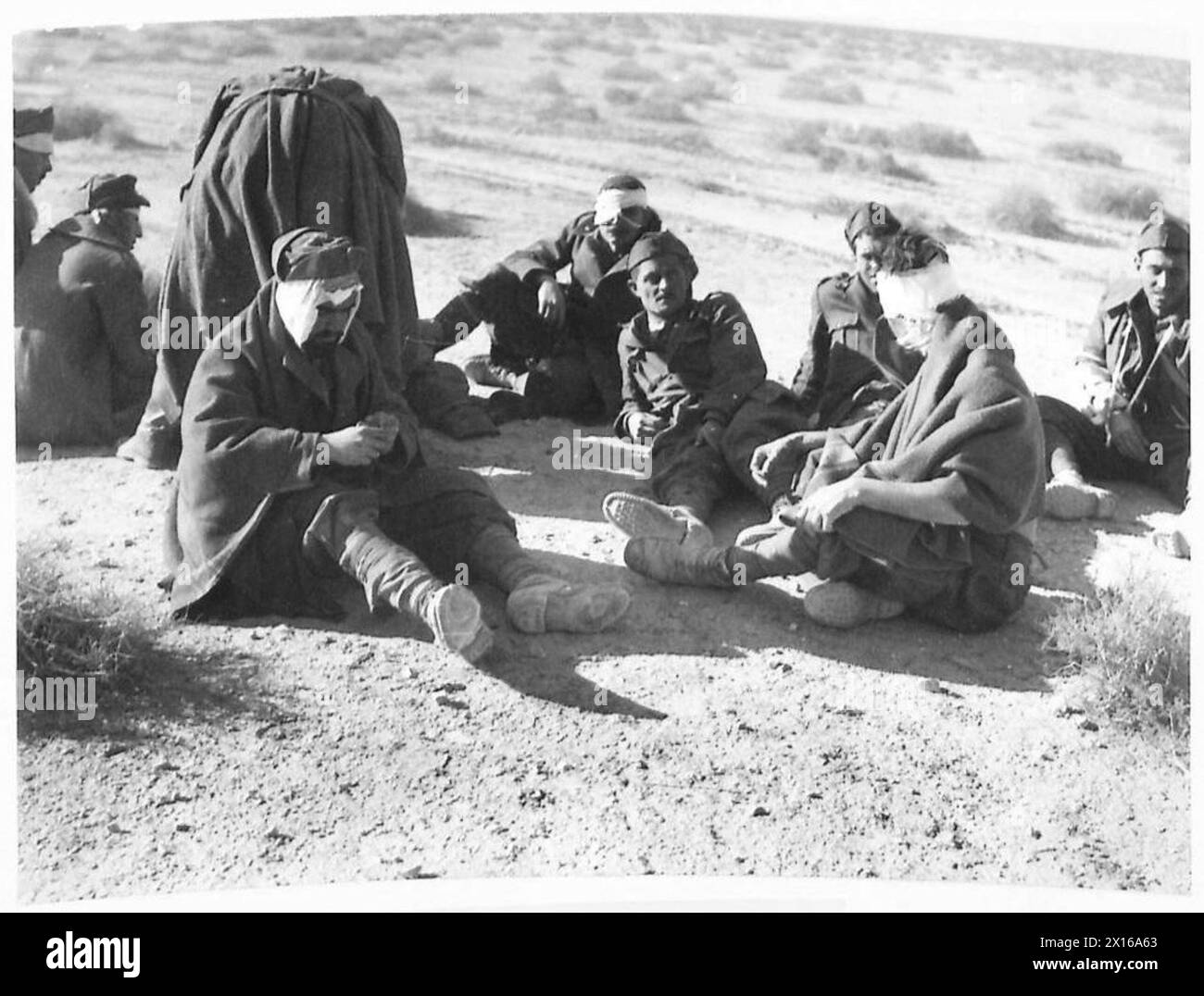 DER FALL VON TOBRUK - italienischer verwundeter Gefangener wartet auf Transport für Krankenhausbehandlung britische Armee Stockfoto