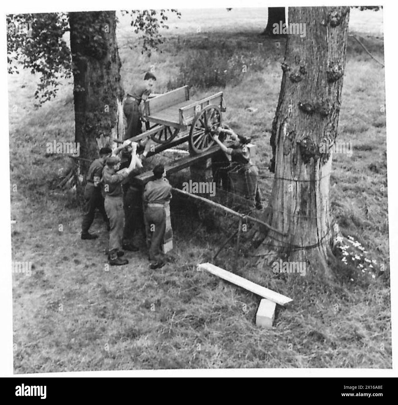 Männer im Hauptquartier des war Office Selection Board in Watford steuern ein Drahthindernis mit verfügbaren Materialien, demonstrieren Problemlösungs- und Trainingsübungen. Stockfoto