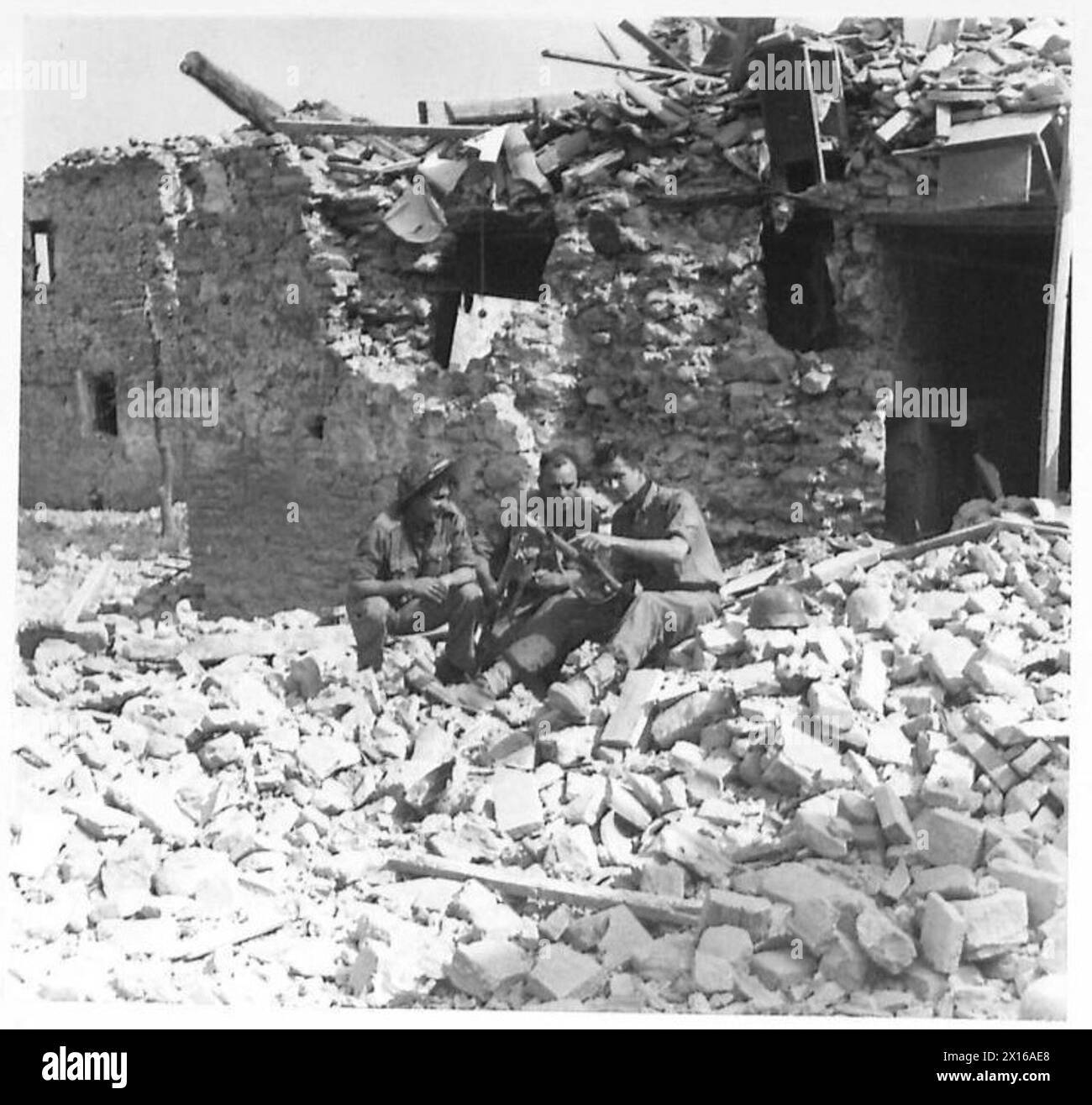 In den Ruinen von Gemmano, verteidigt von deutschen Truppen, ruhten drei Mitglieder des 2/4 K.O.Y.L.I. Mörserzuges während Operationen in Nordafrika, Sizilien, Italien, dem Balkan und Österreich zwischen 1942 und 1946. Stockfoto