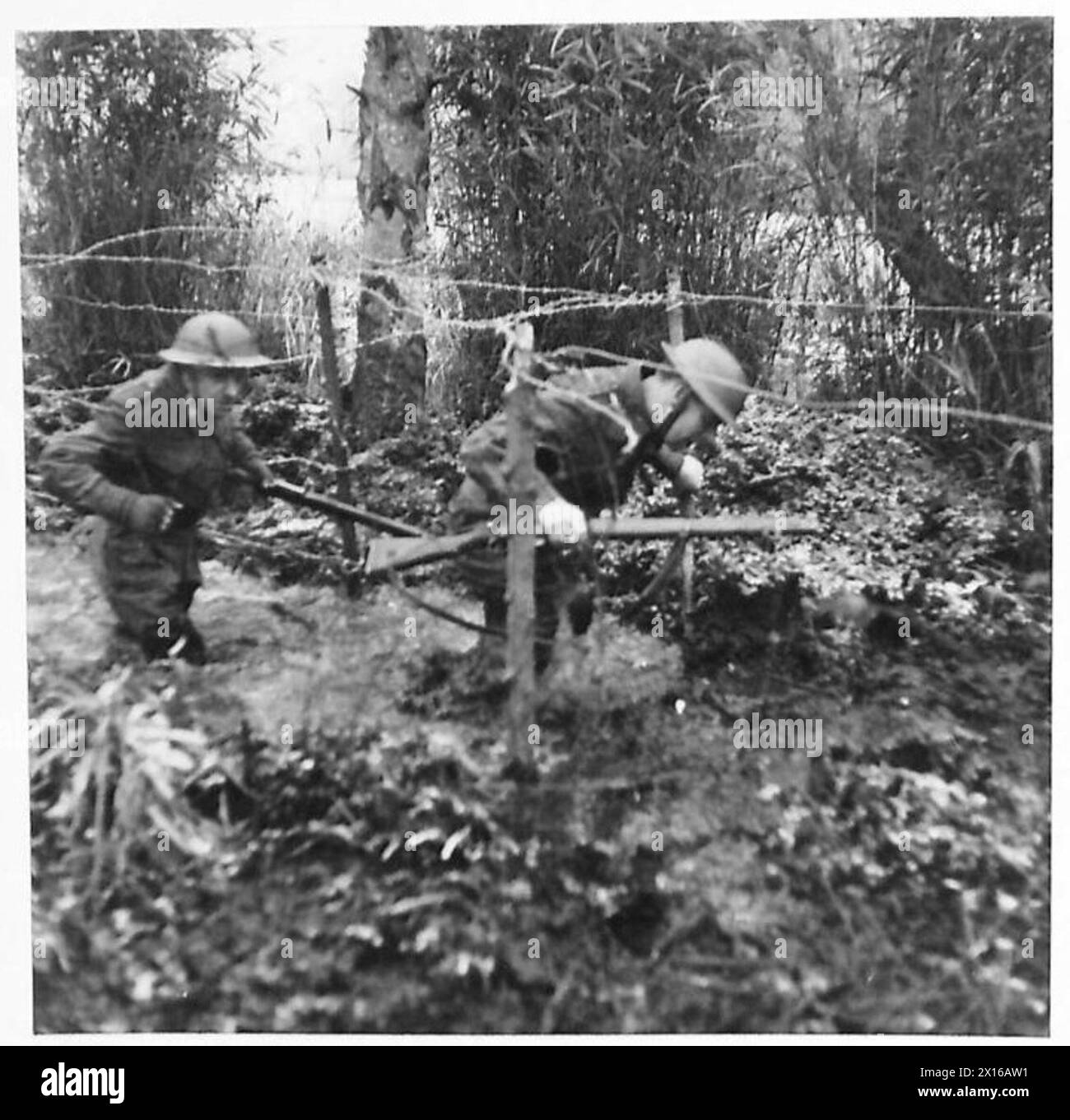 SCHOOL OF BATTLE DRILL - Soldaten waten einen kleinen Fluss mit der Abdeckung, die er als Bildschirm gegen feindliche Beobachtungen der British Army bereitstellt Stockfoto