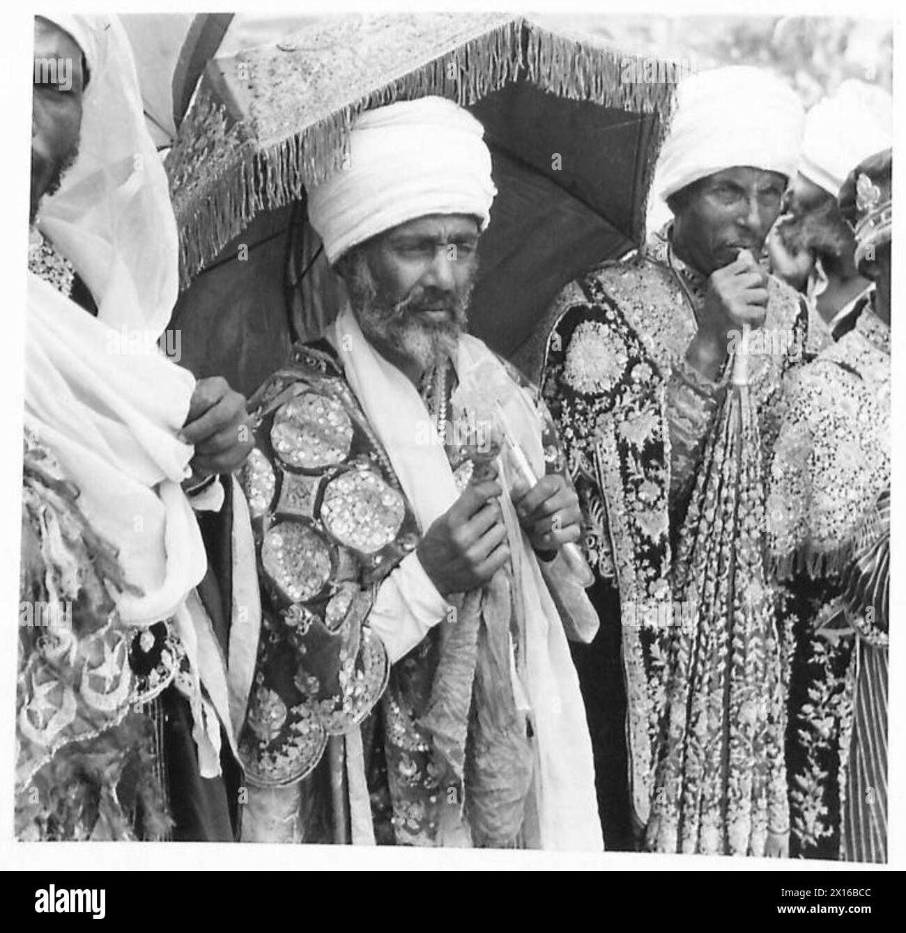 Die Häuptlinge traditioneller Insignien erwarten die Ankunft von Kaiser Haile Selassie in Addis Abeba, die von britischen Armeepersonal beobachtet wird. Stockfoto