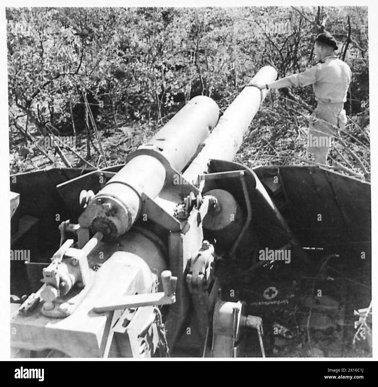 Eine deutsche Selbstfahrkanone, die bei Cerasolo gefangen genommen wurde, misst etwa 150 mm im Kaliber, in gutem Betriebszustand und fast doppelt so groß wie eine Priest Selbstfahrkanone. Die Größe wird von einem Mann dargestellt, der daneben steht. Stockfoto