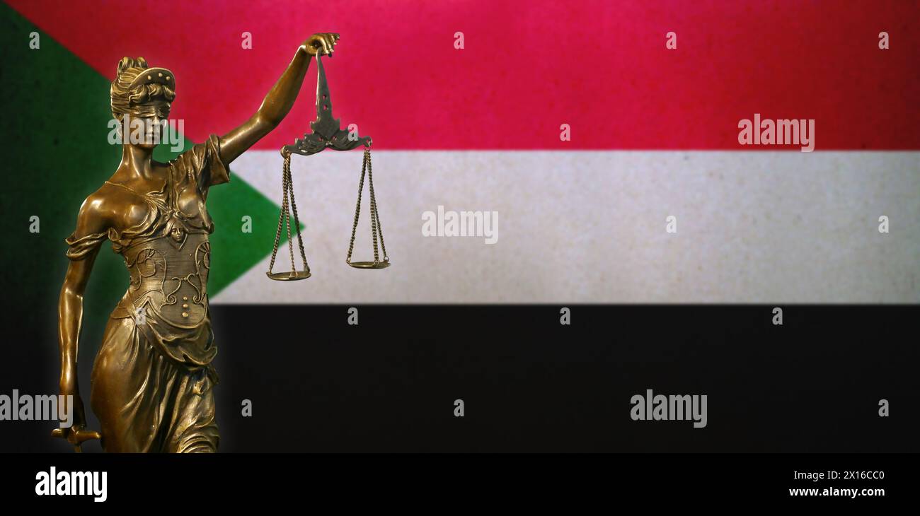 Nahaufnahme einer kleinen Bronzestatuette von Lady Justice vor einer Flagge des Sudan. Stockfoto