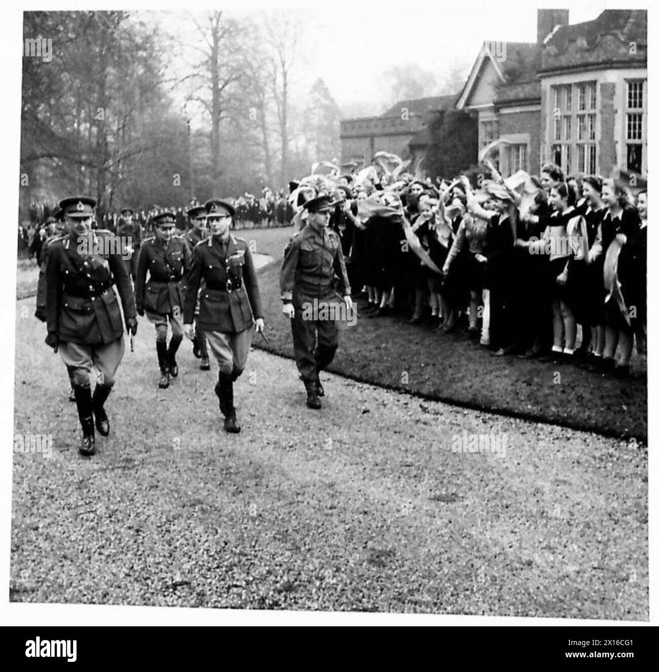 Der König besucht Truppen und durchquert das Gelände einer Mädchenhochschule, wo er von Schülern begrüßt wird. Stockfoto
