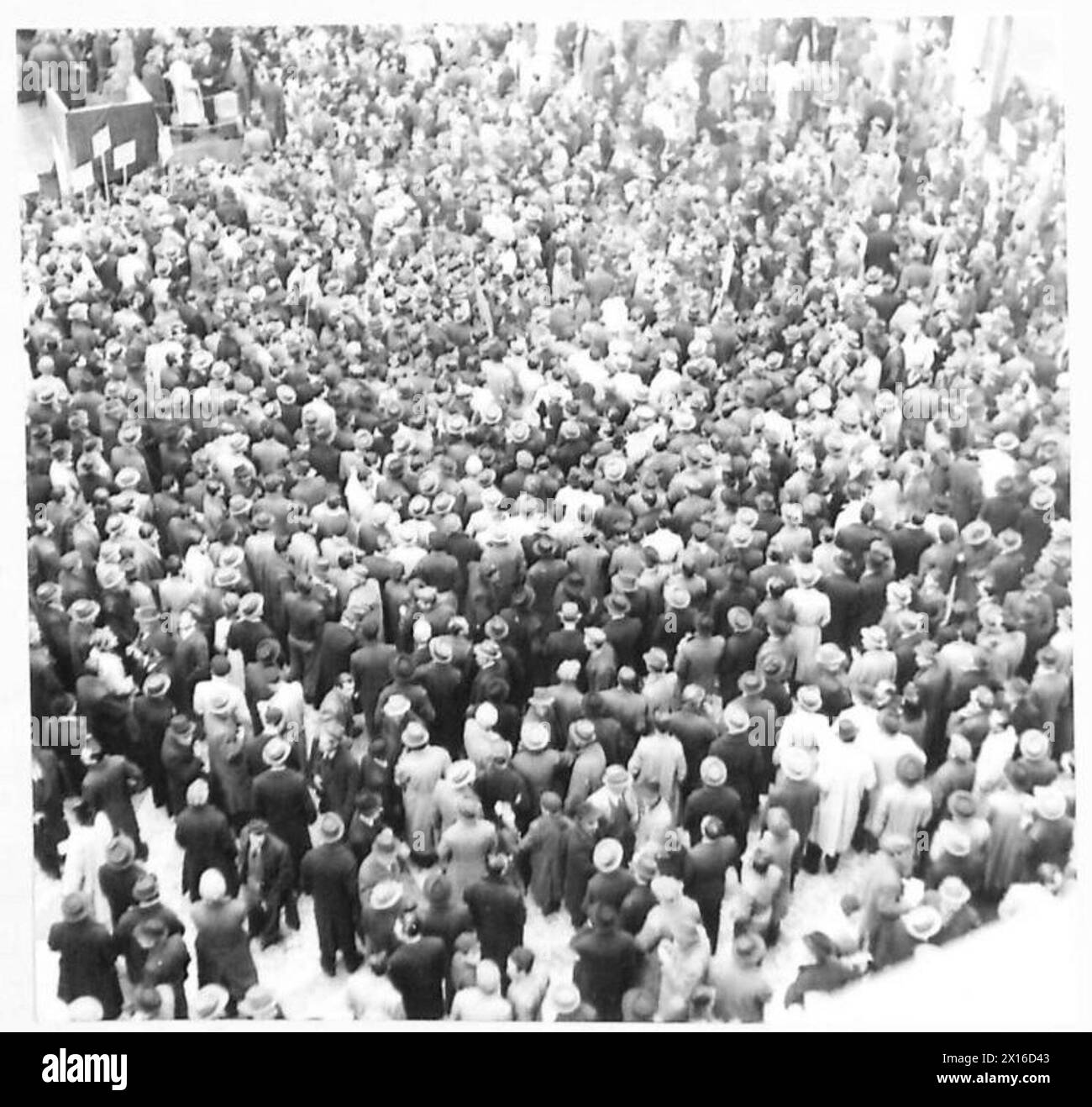 Eine große Menschenmenge nimmt an einem politischen Treffen in Neapel, Italien, Teil, das von britischen Armeepersonal beobachtet wird. Stockfoto