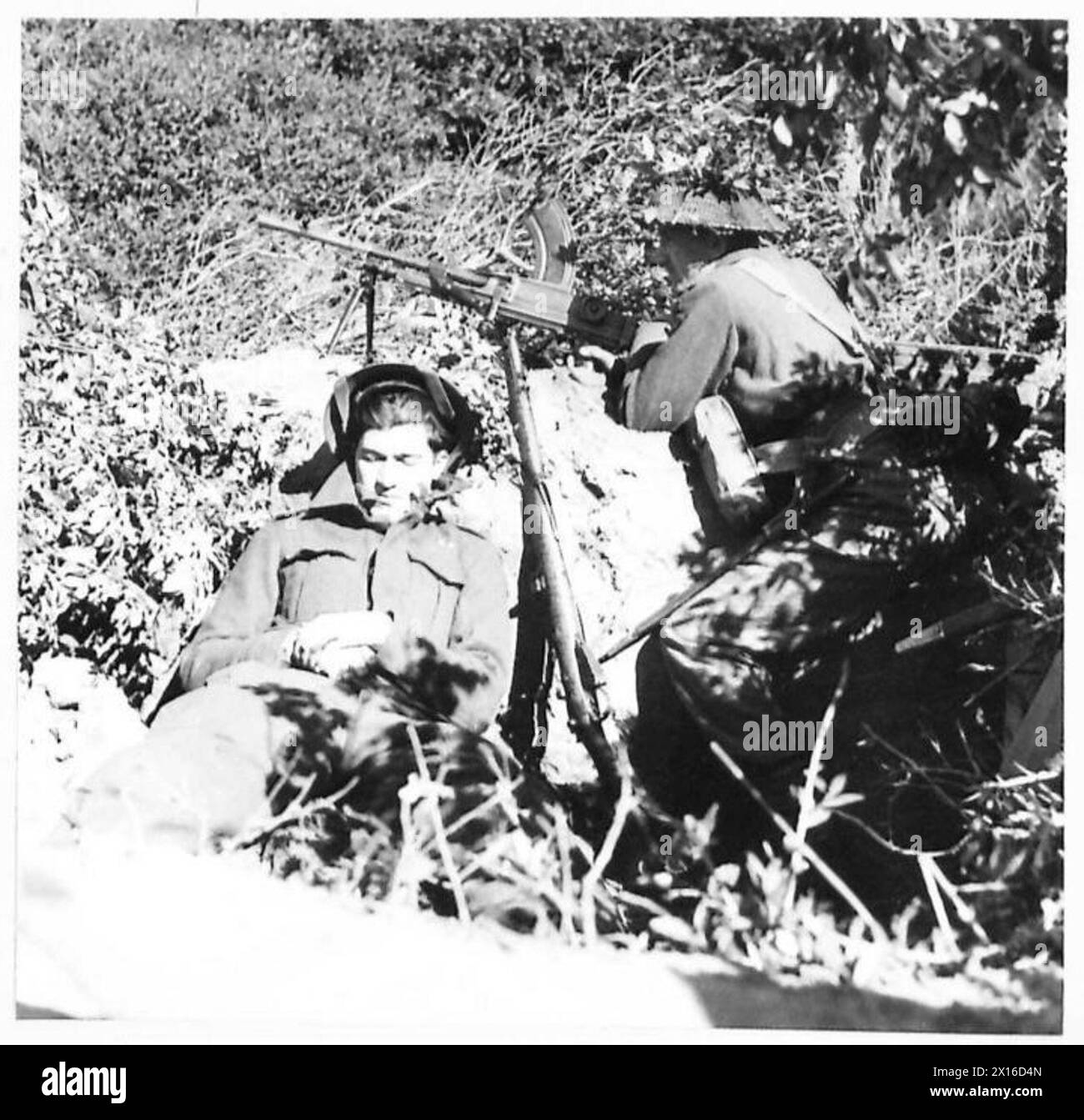 Private Johnson, eine Verstärkung der Königinnen, ruht, während sein Kamerad während der Operationen der Fünften Armee in Italien Wache am Brückenkopf von Anzio hält. Stockfoto