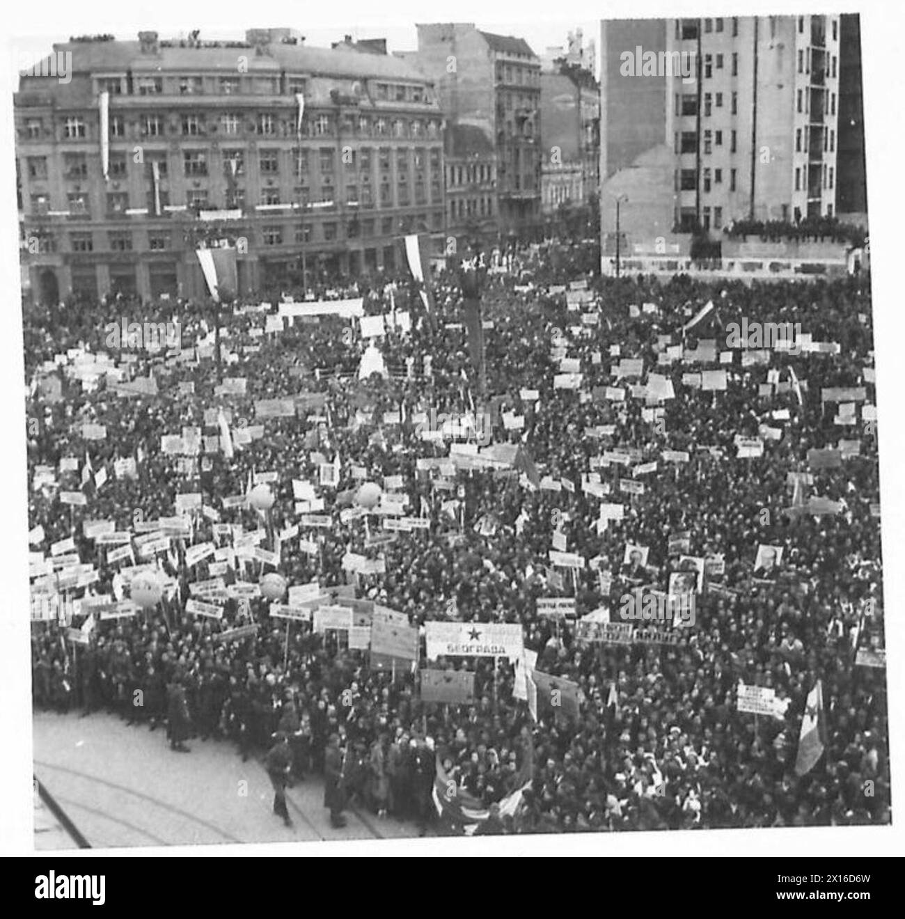 Am 27. März versammeln sich große Menschenmassen in Jugoslawien, die Banner und Fahnen tragen, um öffentliche Redner während der Feierlichkeiten zu hören. Stockfoto