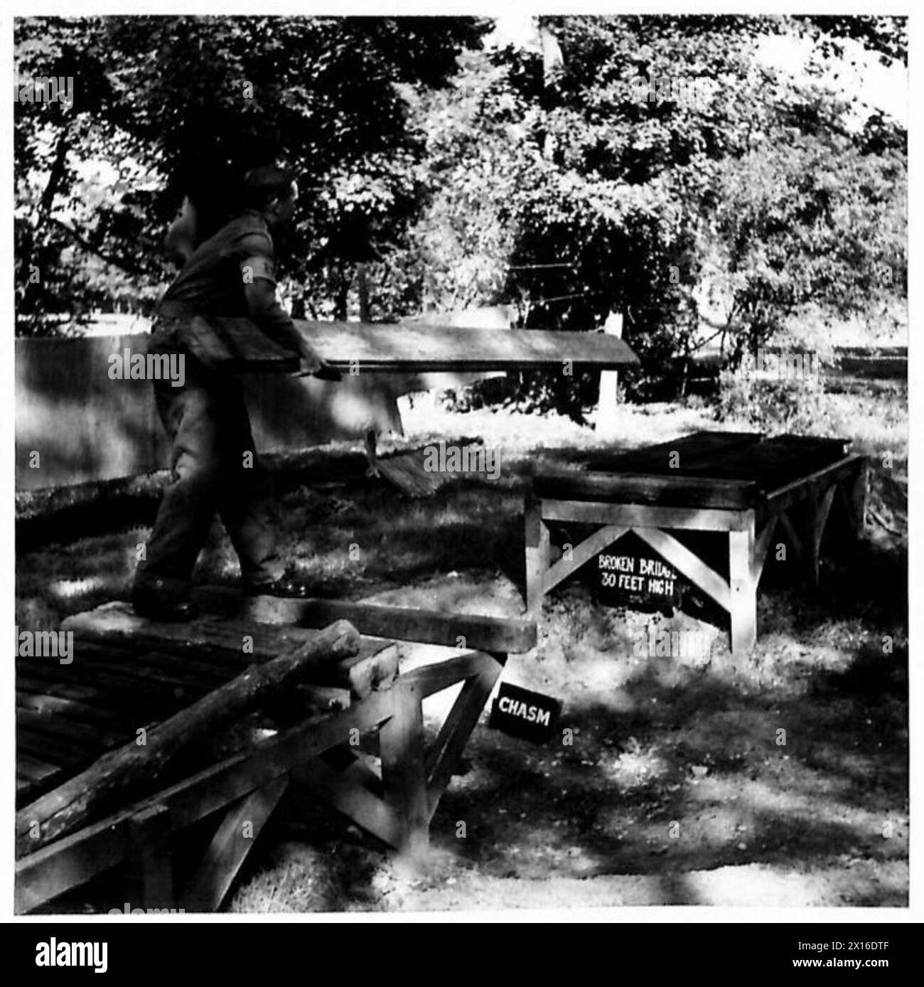 WOSB-Mitarbeiter steuern einzelne Hindernisse in der WOSB Garston bei Watford, einschließlich einer kaputten Brücke über eine 30-Zoll-Kluft, British Army. Stockfoto