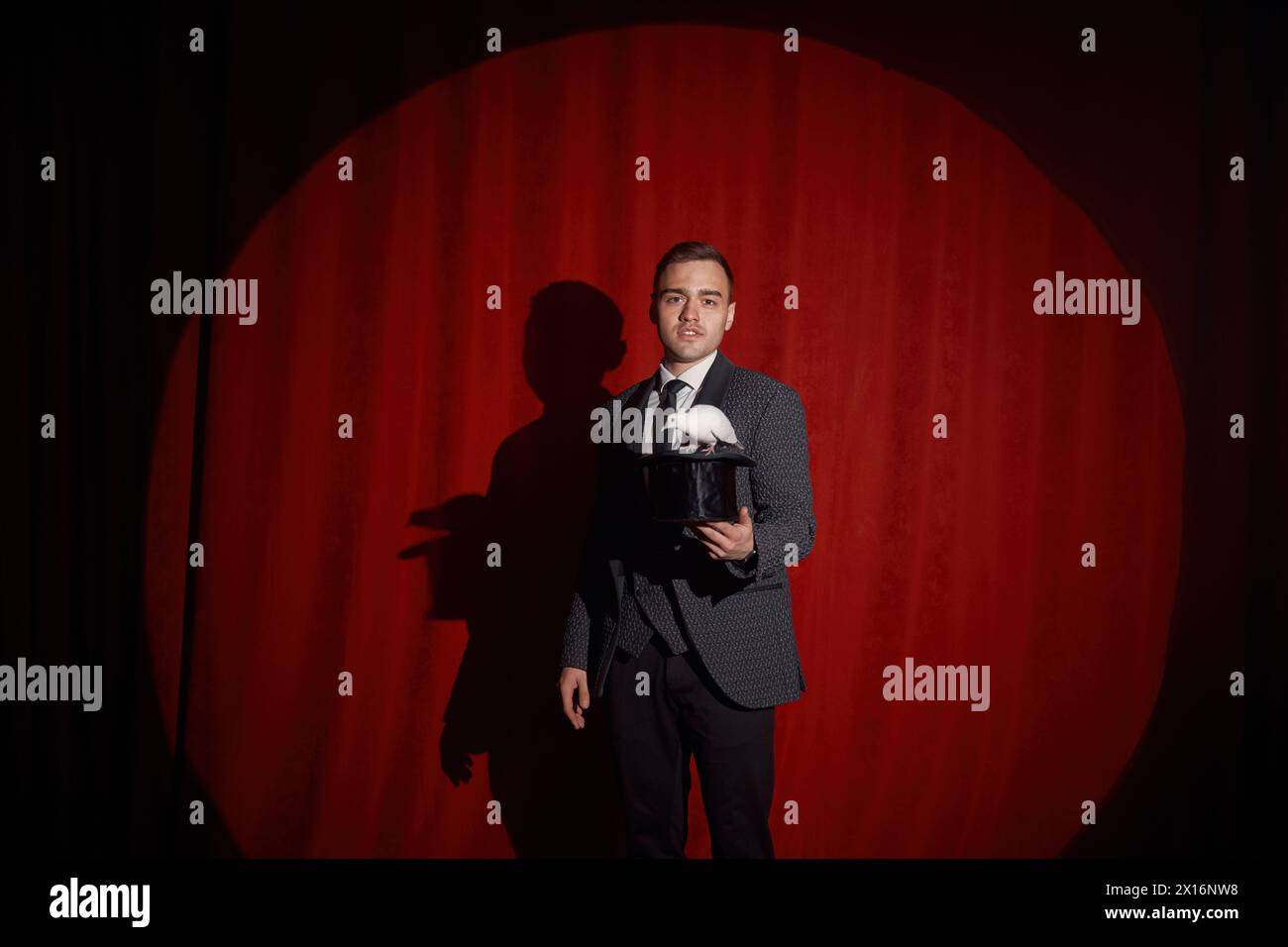 Eleganter, geheimnisvoller Illusionist, der Tricks mit Kaninchen zeigt Stockfoto