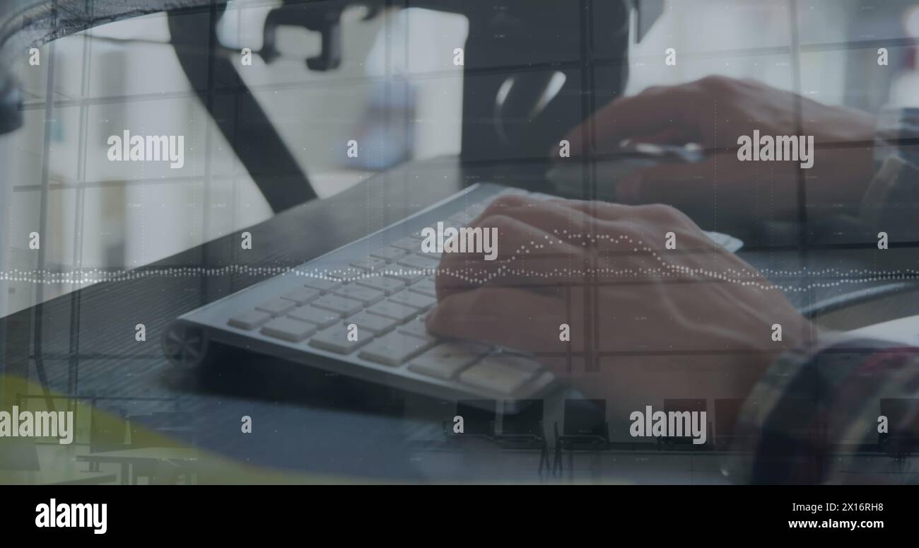 Die Hände eines jungen kaukasischen Geschäftskreativen werden gezeigt, indem sie auf einer Computertastatur und Mo schreiben Stockfoto