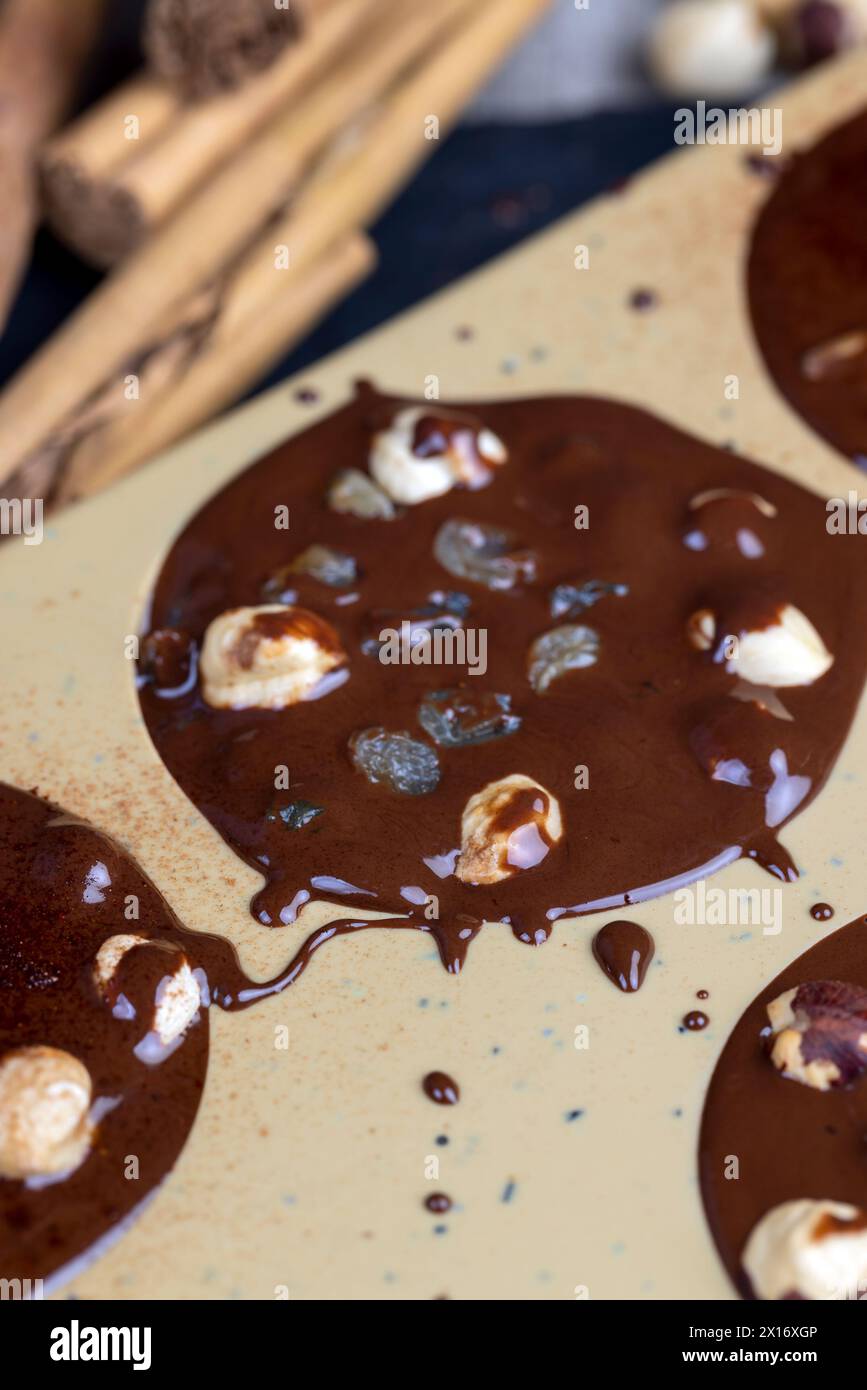 Geschmolzene Milchschokolade mit Nüssen, kochende Schokoladentafeln mit heißer Milchschokolade und Nüssen Stockfoto