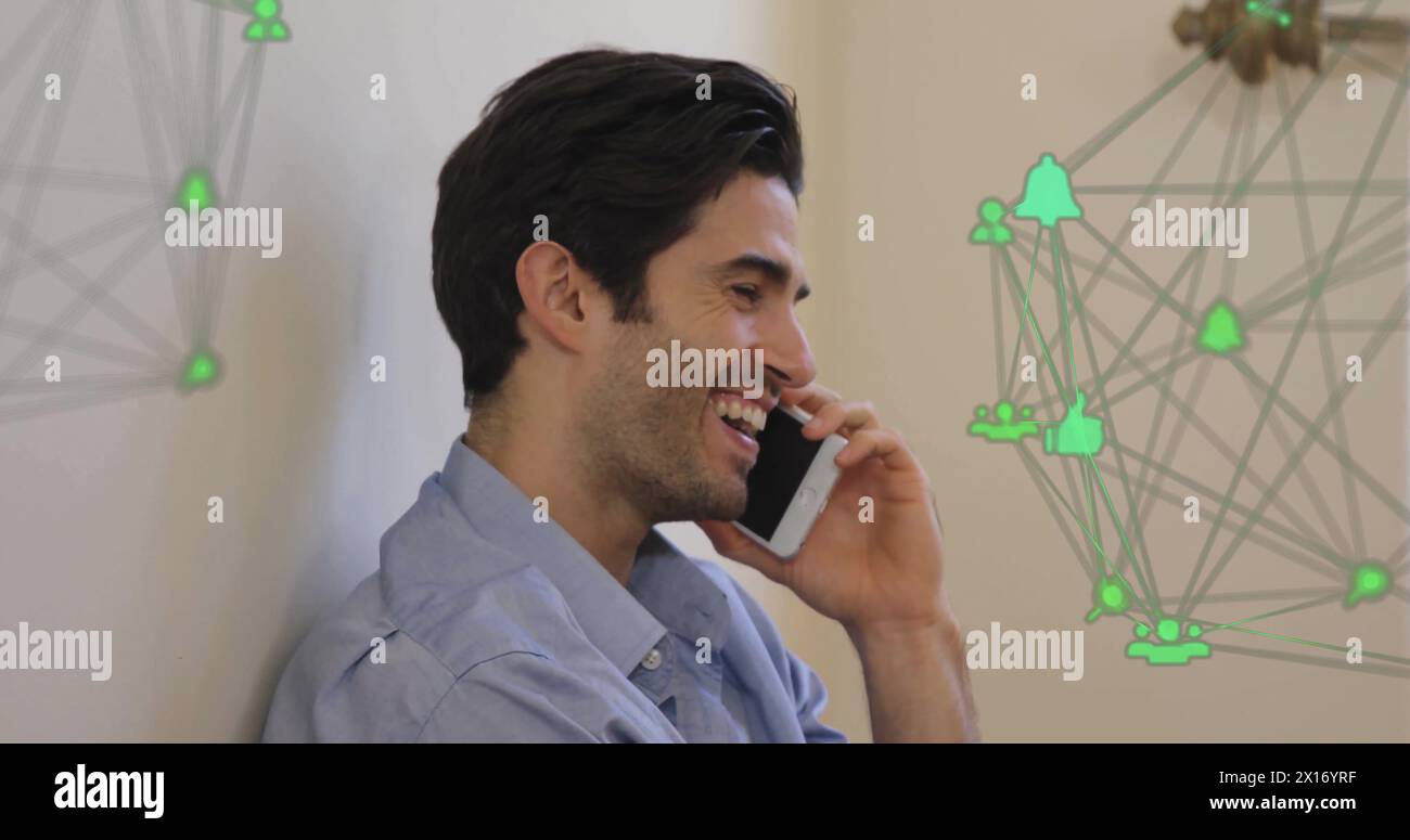 Bild von verbundenen Ikonen, die Kugeln über lächelnden kaukasiern bilden, die mit dem Handy sprechen Stockfoto