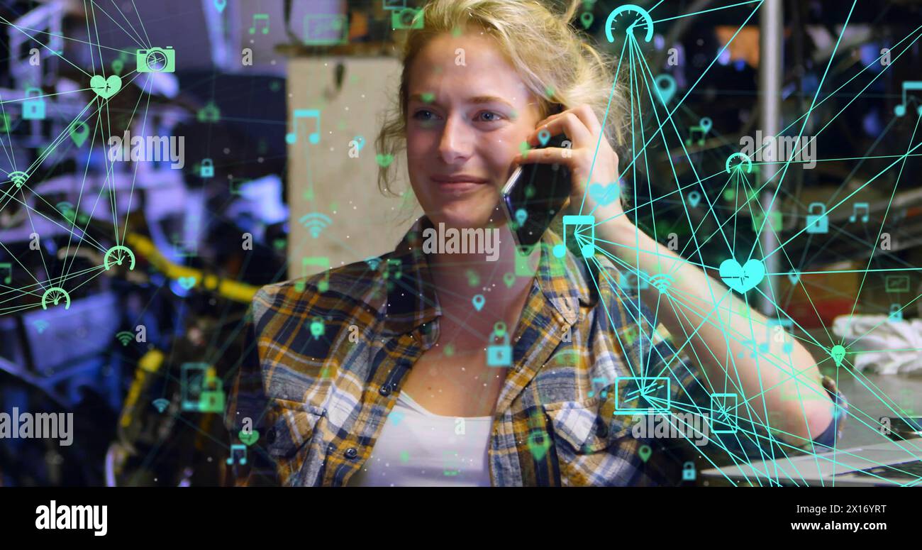 Bild von verbundenen Ikonen Globen über der schönen kaukasischen Frau, die auf dem Handy spricht Stockfoto