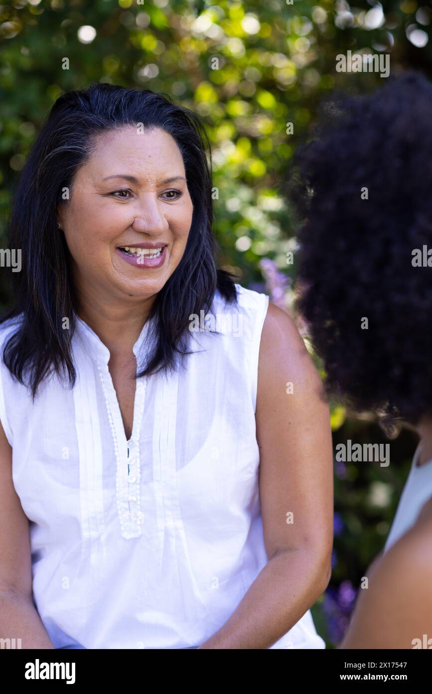 Eine reife Frau spricht mit ihrer kleinen Tochter zu Hause im Garten Stockfoto