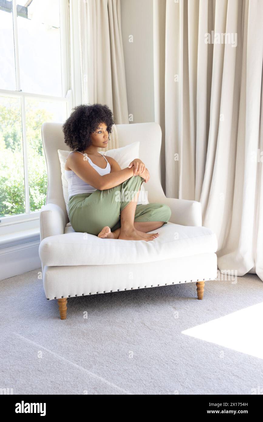 Birassische junge Frau, die zu Hause sitzt und eine Tafel hält Stockfoto