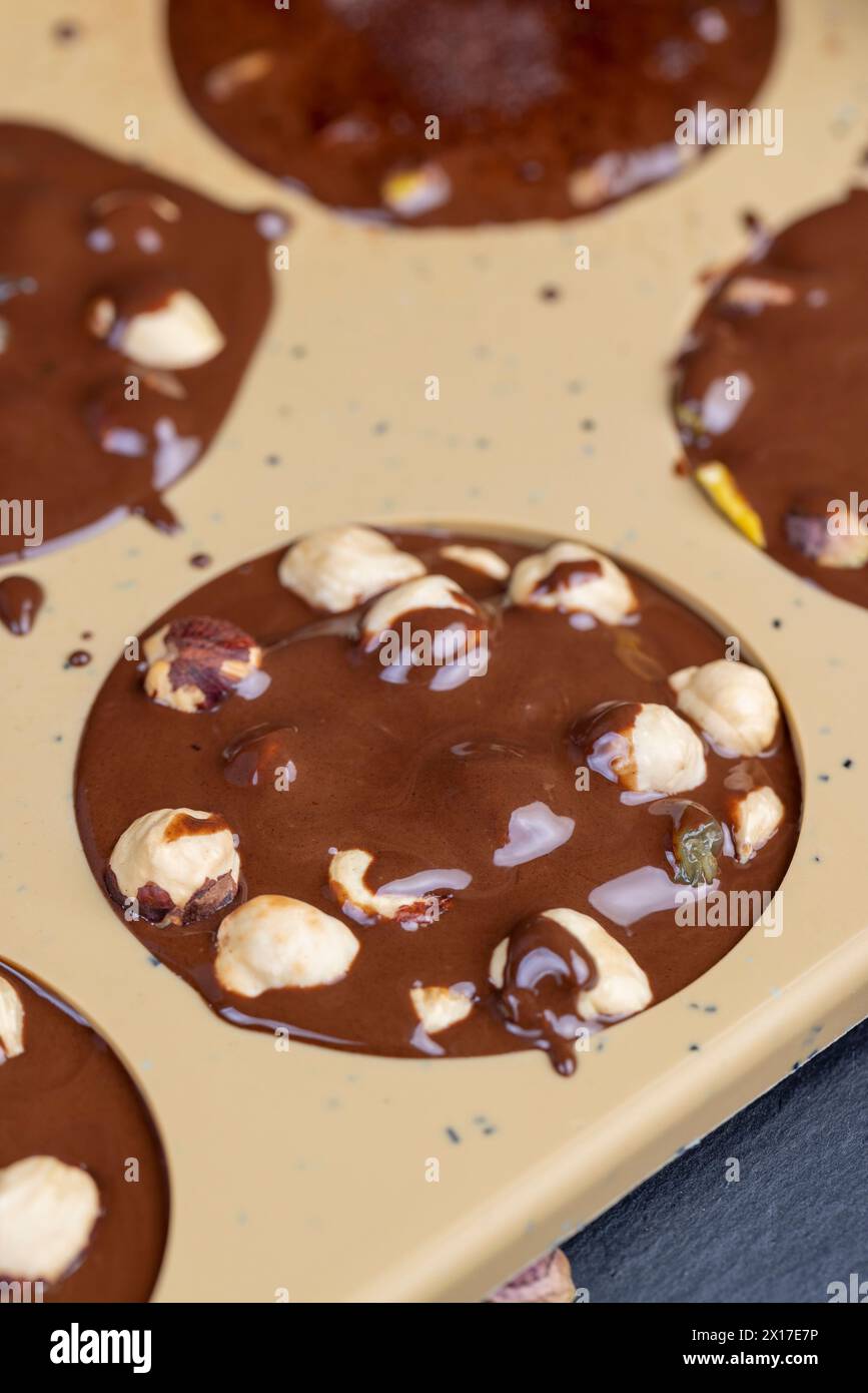 Geschmolzene Milchschokolade mit Nüssen, kochende Schokoladentafeln mit heißer Milchschokolade und Nüssen Stockfoto