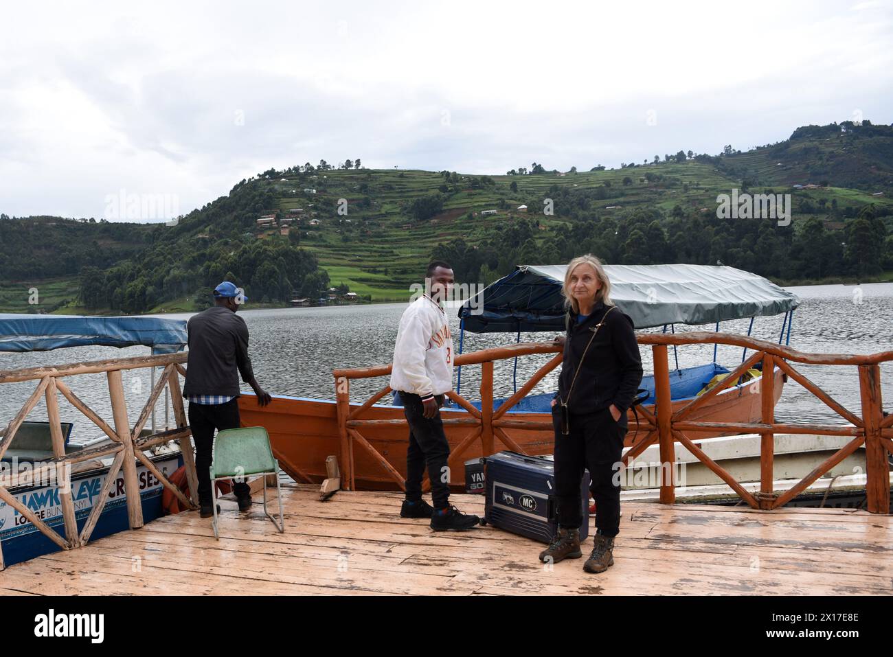 Ein eifriger europäischer Tourist kommt am ruhigen Pier ihres Hotels am See an, umgeben von der ungezähmten Schönheit des Bunyonyi-Sees in Uganda. Umgeben von Stockfoto