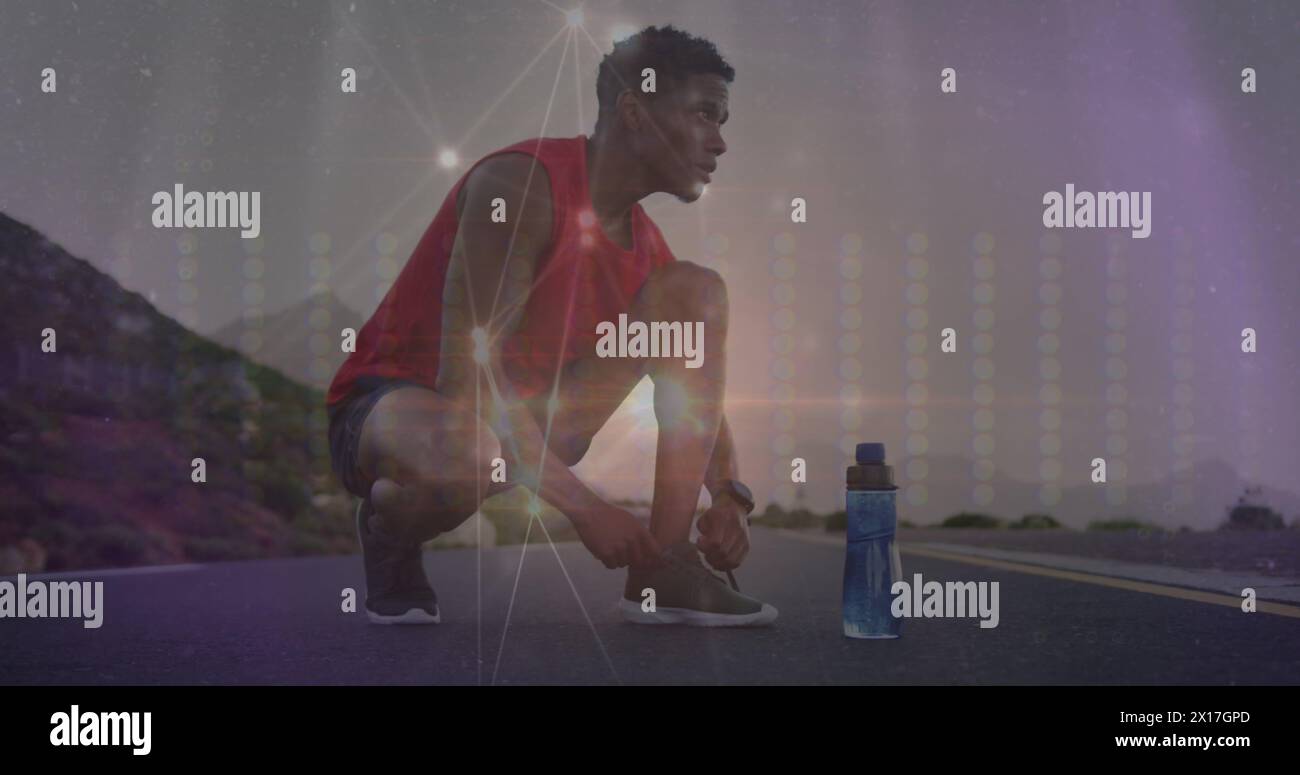 Bild des Netzes von Verbindungen über afroamerikanischen Mann, der Schuhe bindet Stockfoto