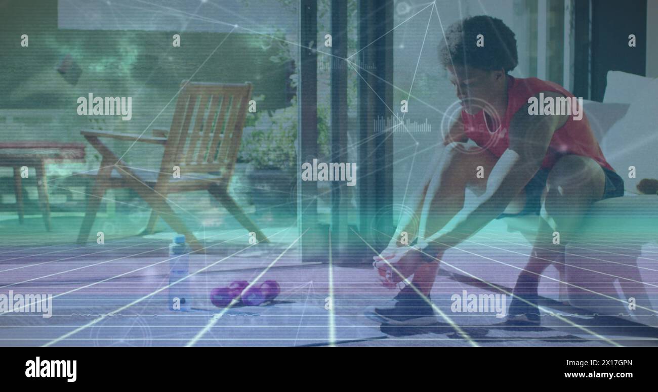 Bild des Netzes von Verbindungen über afroamerikanischen Mann, der Schuhe bindet Stockfoto