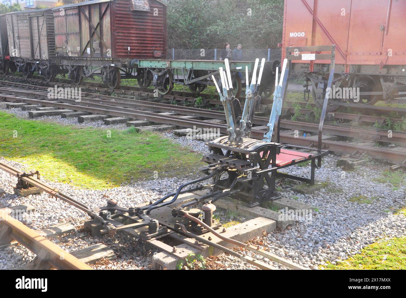 Stellt Bedienhebel und Verbindungen auf den Bahnstrecken in Bristol Docks mit altem rollendem Material im Hintergrund. Teil des alten Eisenbahnsystems wh Stockfoto