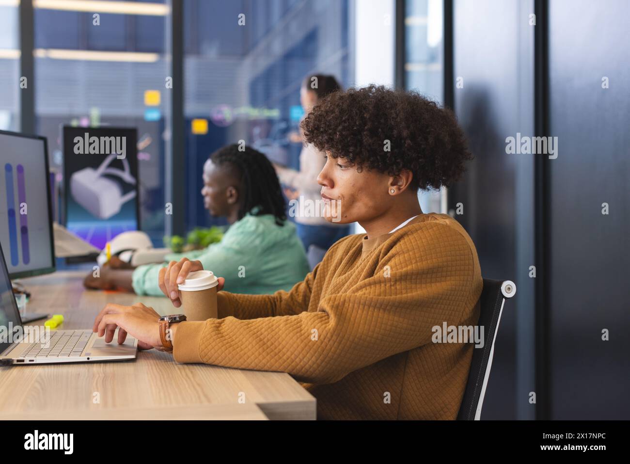 Verschiedene Kollegen, die sich auf die Arbeit in modernen Büros mit Laptops konzentrieren Stockfoto