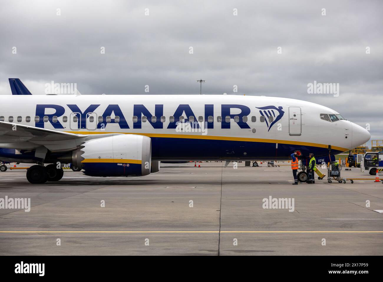 Ryanair Boeing 737 Max auf Asphalt mit Besatzung und Ausrüstung, bewölkter Himmel. Stockfoto