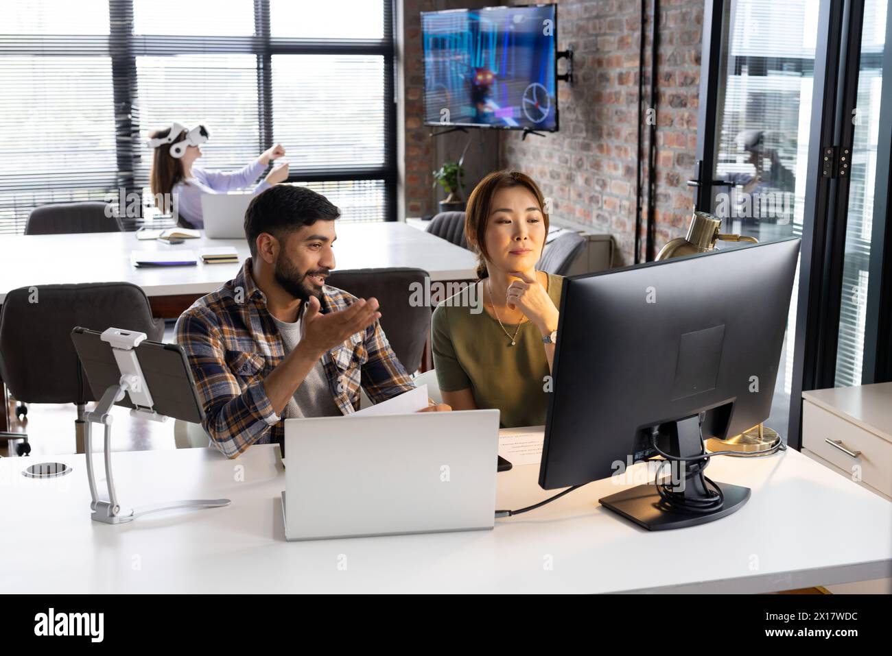 Asiatische Profis arbeiten an Computern in einem modernen Geschäftsbüro Stockfoto