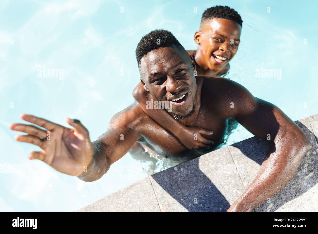 Afroamerikaner Vater und Sohn genießen das Schwimmen im Pool zu Hause Stockfoto