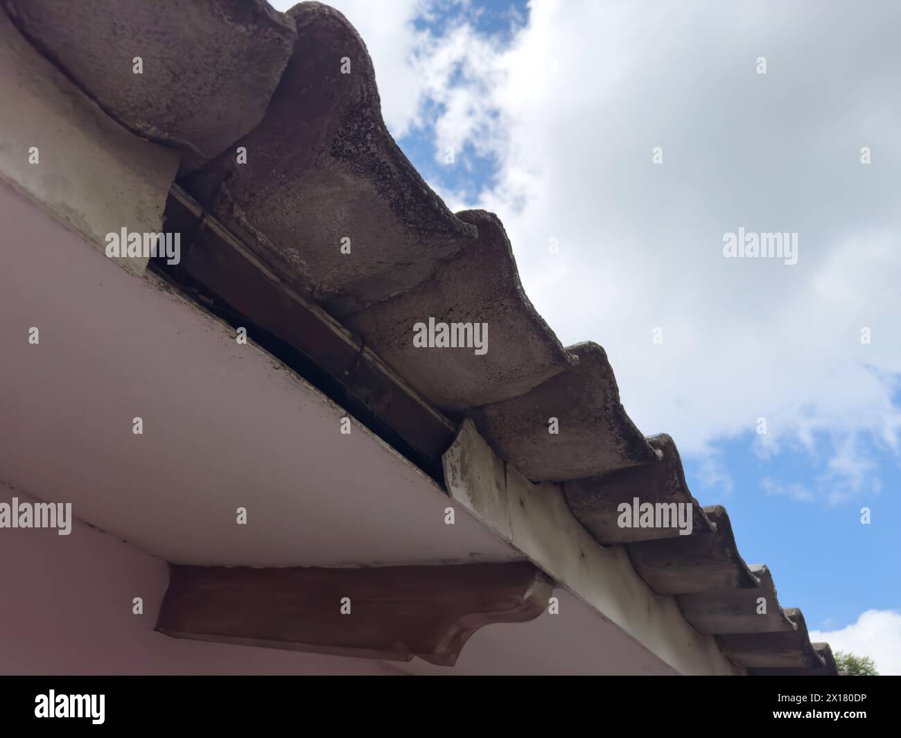 Altes Dach mit Loch im Holz nah oben auf blauem Himmel Hintergrund Stockfoto