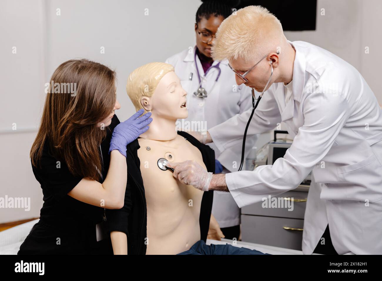 Eine Ärztin untersucht sorgfältig eine männliche Schaufensterpuppe in einer medizinischen Umgebung. Stockfoto