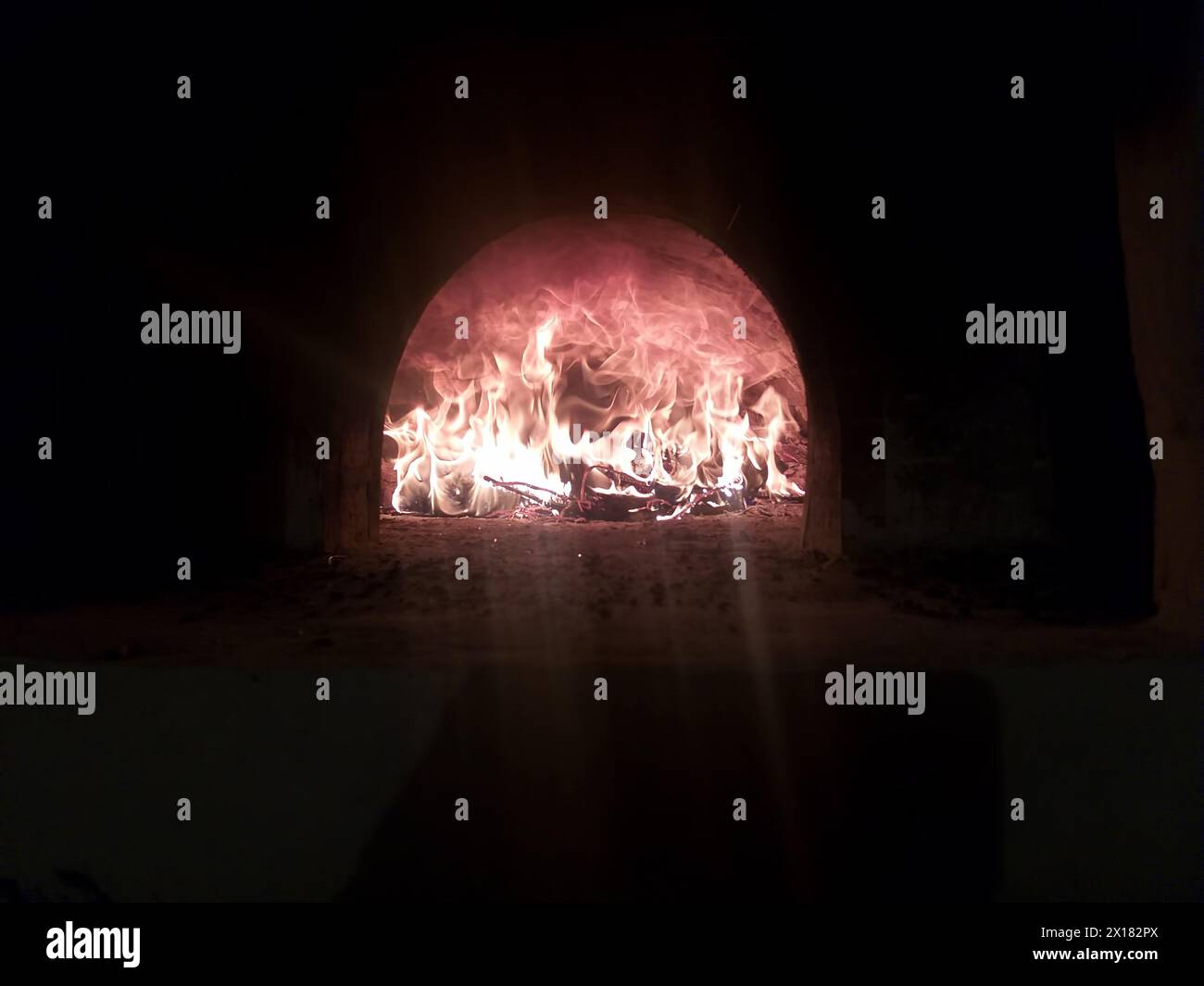 Ein heißes Feuer brennt im Ofen im Dunkeln Stockfoto