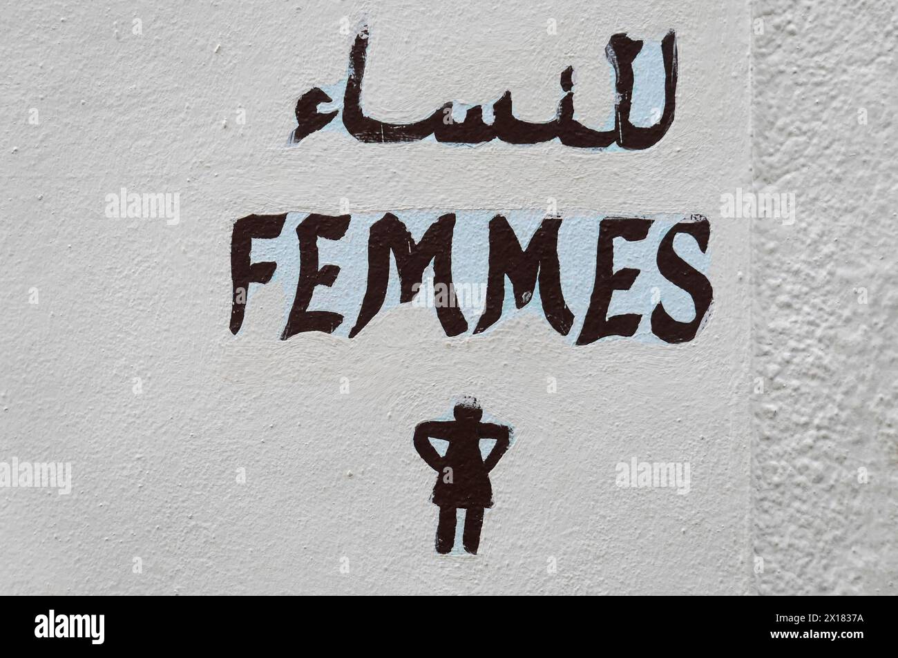 Meknes, WC-Schild für Frau mit Inschriften in Arabisch und Französisch auf einer weißen Wand, Nordmarokko, Marokko Stockfoto