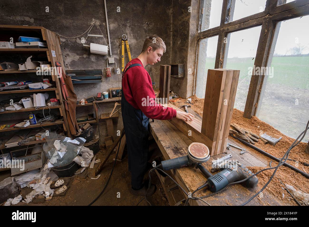 Der junge Mann baut einen Tisch in seiner Werkstatt in Mecklenburg-Vorpommern Stockfoto
