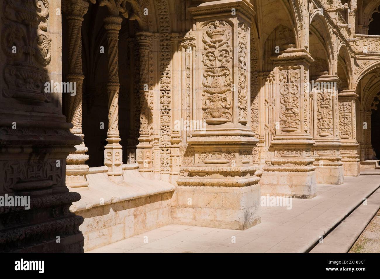 Altes Gebäude mit Säulen und Bögen, dekoriert mit architektonischen Details im Innenhof des Klosters Jeronimos in Lissabon, Portugal Stockfoto