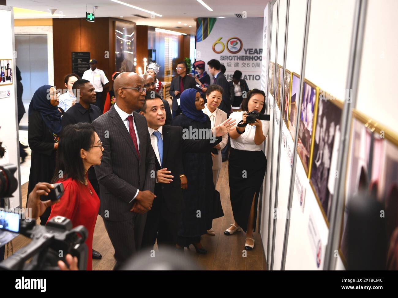 (240415) -- dar es SALAAM, 15. April 2024 (Xinhua) -- der tansanische Minister für auswärtige Angelegenheiten und ostafrikanische Zusammenarbeit Januar Makamba (2. L, Front), der chinesische Botschafter in Tansania Chen Mingjian (1. L, Front) und andere Teilnehmer besuchen eine Fotoausstellung während eines Empfangs in dar es Salaam, Tansania, am 15. April 2024. China und Tansania hielten am Montag in dar es Salaam den Empfang ab, um den 60. Jahrestag der Aufnahme diplomatischer Beziehungen zwischen den beiden Ländern zu feiern. (Chinesische Botschaft in Tansania/Handout via Xinhua) Stockfoto