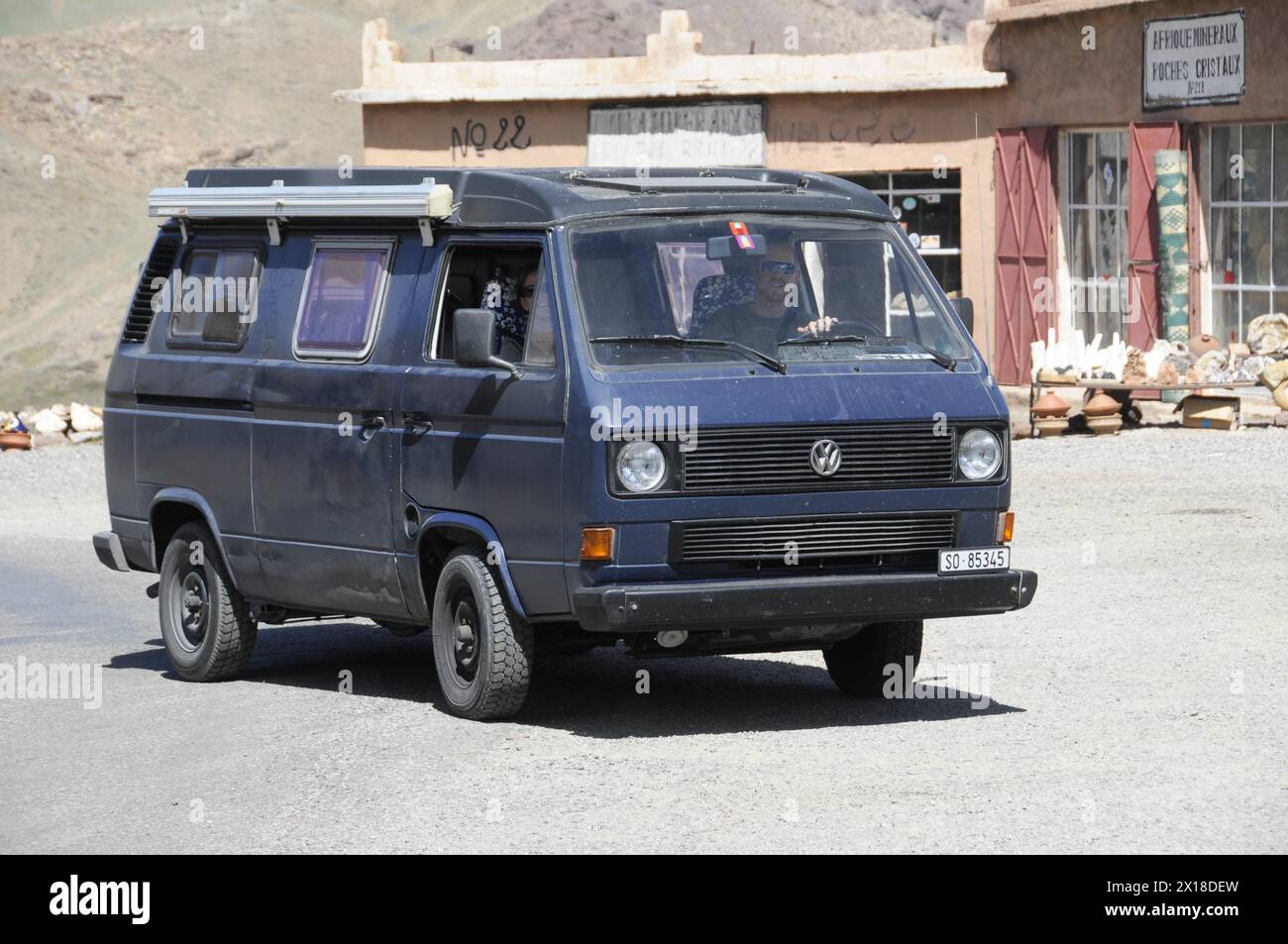 Tichka Pass, Col du Tichka, 2260 m, ein alter Volkswagen Bus fährt auf einer Straße durch die Wüste, Marokko Stockfoto