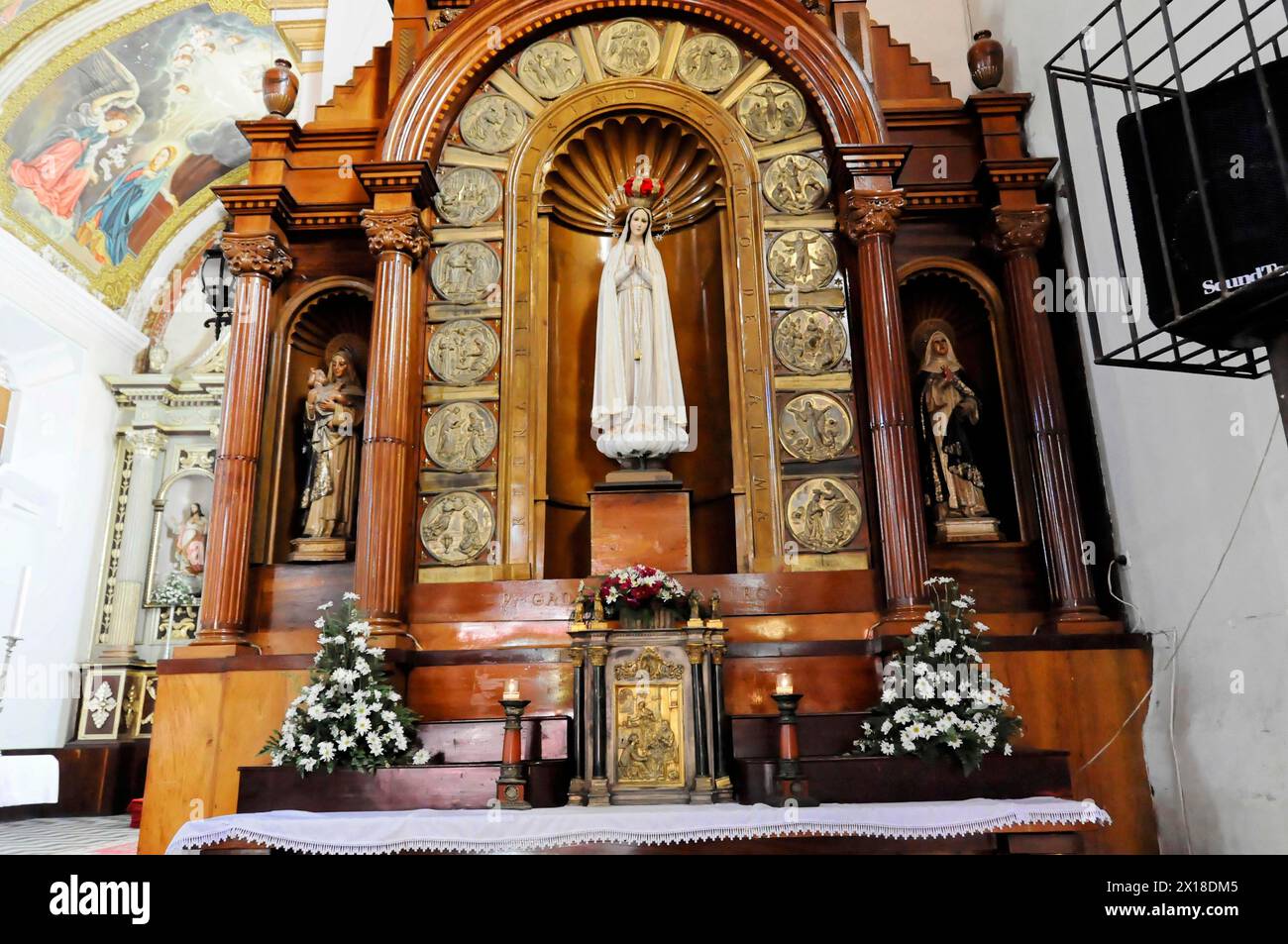 Kirche La Merced, erbaut um 1762, Leon, Nicaragua, ein Altar mit einer Marienstatue, umgeben von Heiligen, Kerzen und Blumen Stockfoto