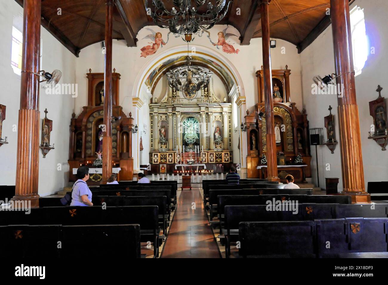 Kirche La Recoleccion, erbaut 1786, Leon, Nicaragua, Gläubige sitzen in einer Kirche mit Holzbänken und einem reich verzierten Altar, Mittelamerika Stockfoto