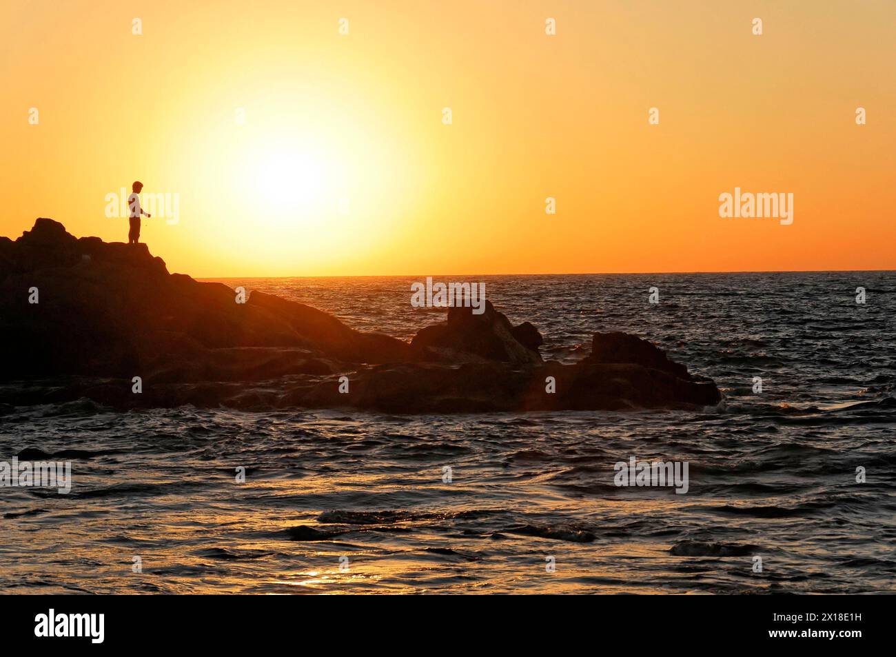 Strand in der Nähe von Poneloya, Las Penitas, Leon, Nicaragua, Silhouette einer Person auf Felsen am Meer bei Sonnenuntergang strahlt Frieden aus, Mittelamerika, Zentral Stockfoto