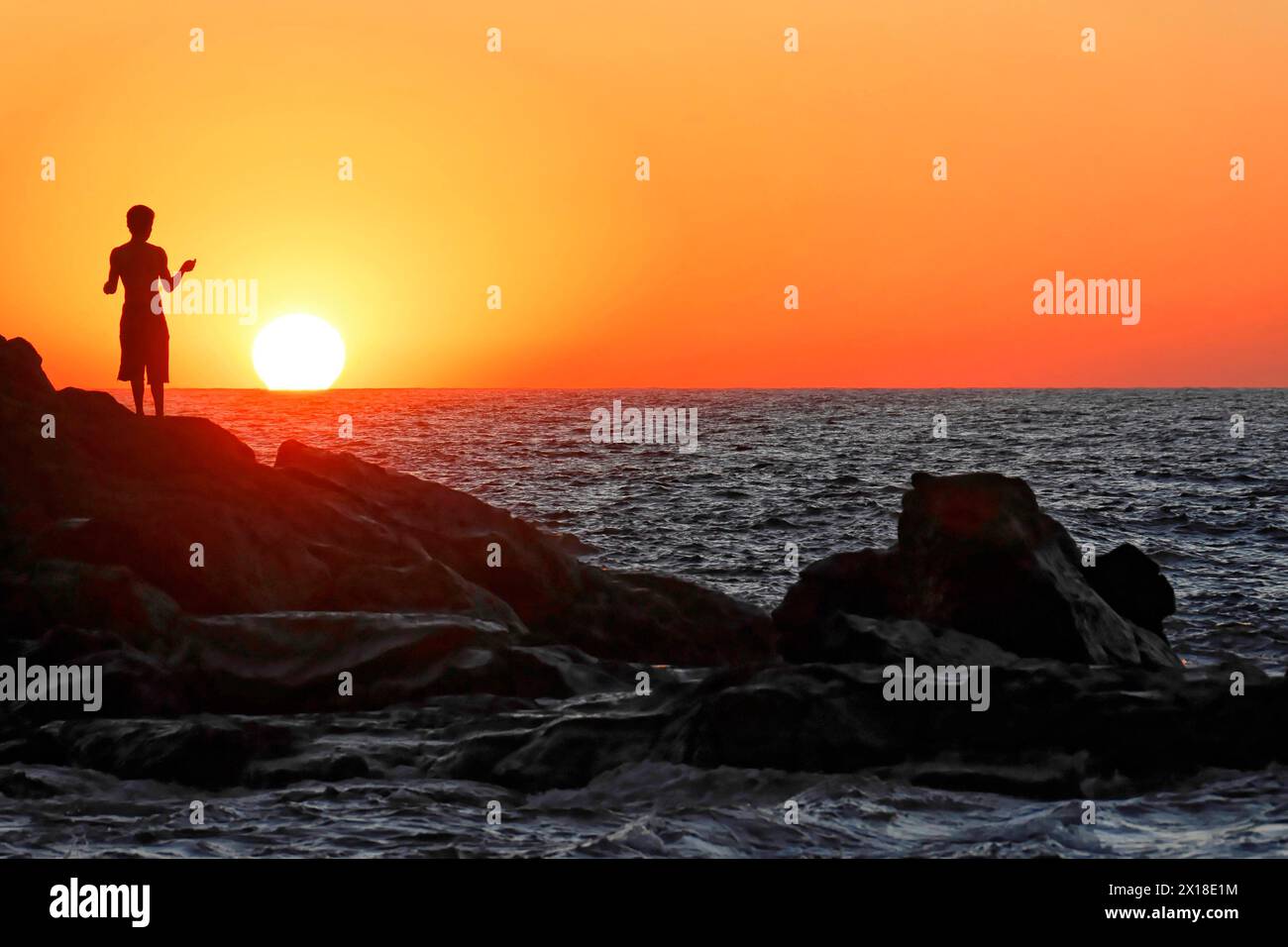 Strand in der Nähe von Poneloya, Las Penitas, Leon, Nicaragua, Eine Frau fotografiert den Sonnenuntergang über dem Meer mit ihrem Handy, Mittelamerika, Mittelamerika Stockfoto