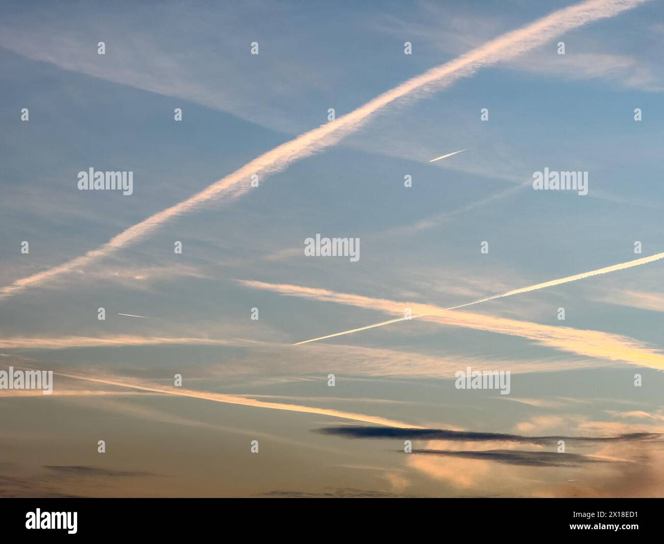Mehrere Dutzend von Kondensationsspuren hohe dünne Wolken, die künstlich durch Flugzeugtriebwerke erzeugt wurden, die mit einem Jet-Jet künstlich hergestellt wurden Stockfoto
