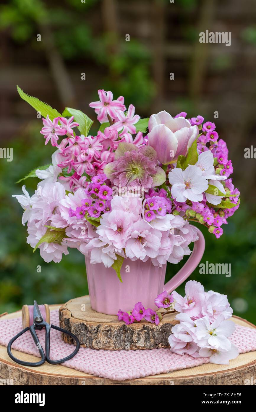 Romantisches Bouquet aus fastenrose, Tulpe, Hyazinthen, bergenie und japanischer blühender Kirsche Stockfoto