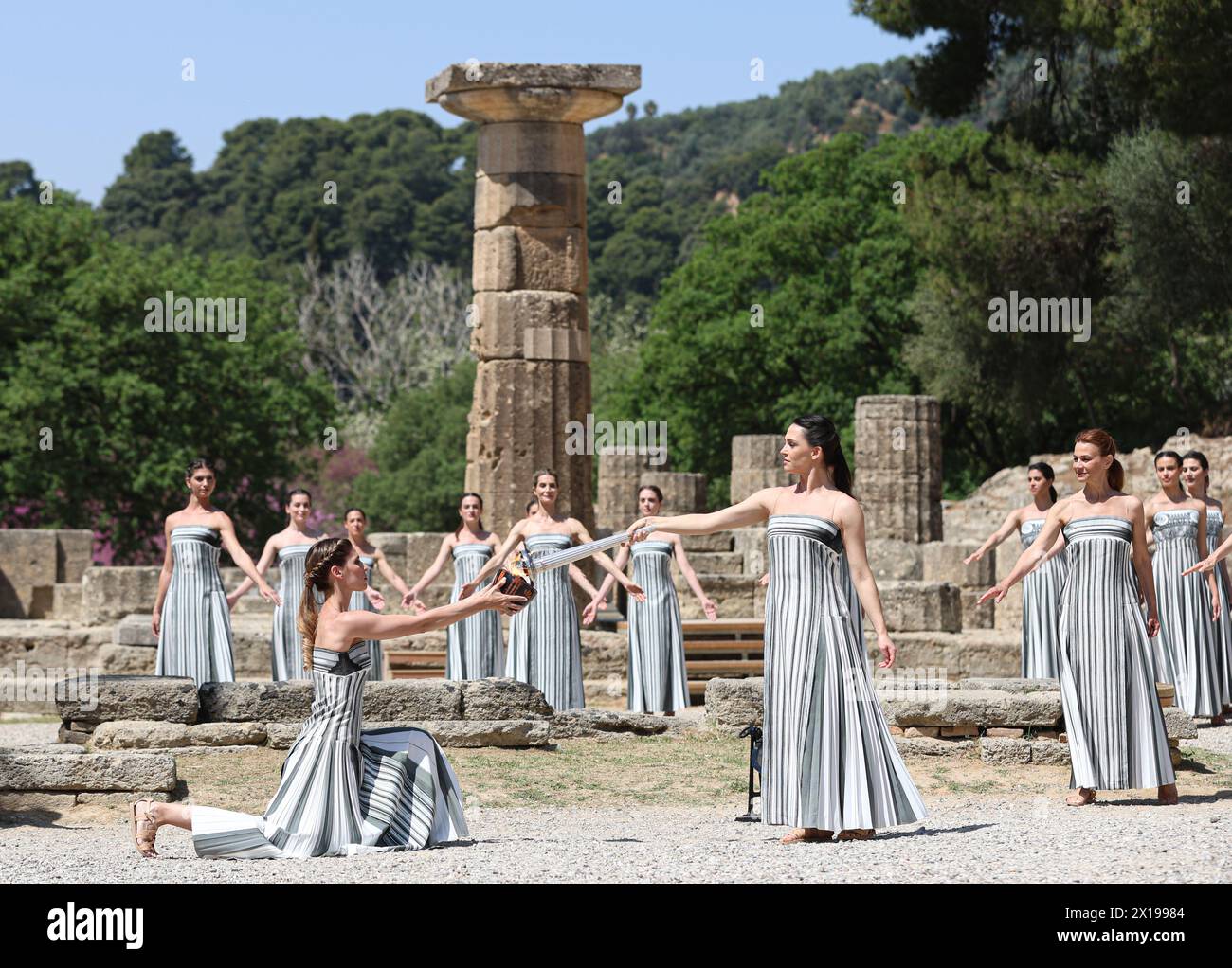 Peking, Griechenland. April 2024. Die griechische Schauspielerin Mary Mina (Front R), die die Rolle der Hohepriesterin spielt, zündet die Flamme während der letzten Probe der olympischen Flammenbeleuchtung für die Olympischen Sommerspiele 2024 im antiken Olympia, Griechenland, am 15. April 2024 an. Quelle: Li Jing/Xinhua/Alamy Live News Stockfoto