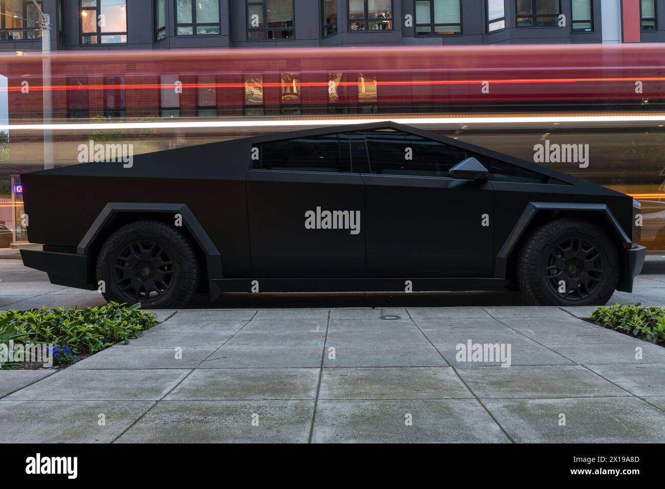 Seattle, USA. April 2024. Ein geparkter, mattschwarzer Tesla Cybertruck auf der 3. Ave in der Innenstadt, als Fahrzeuge vorbeifahren. Stockfoto