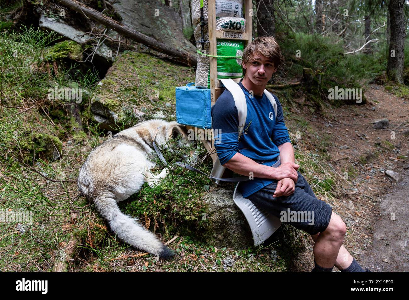 Poprad, Slowakei. April 2024. Ein Bergportier mit seinem Hund und einer schweren Last auf einem Weg im Tal der Mala Studena in der Hohen Tatra (Vysoke Tatry) in der Nordslowakei. Die Träger liefern Waren zu Herbergen und Unterkünften in hohen Bergen. Die Temperaturen in diesem April sind ungewöhnlich hoch, was mehr Touristen anzieht und dazu führt, dass der Schnee in höheren Lagen schmilzt. (Credit Image: © Dominika Zarzycka/SOPA images via ZUMA Press Wire) NUR REDAKTIONELLE VERWENDUNG! Nicht für kommerzielle ZWECKE! Stockfoto