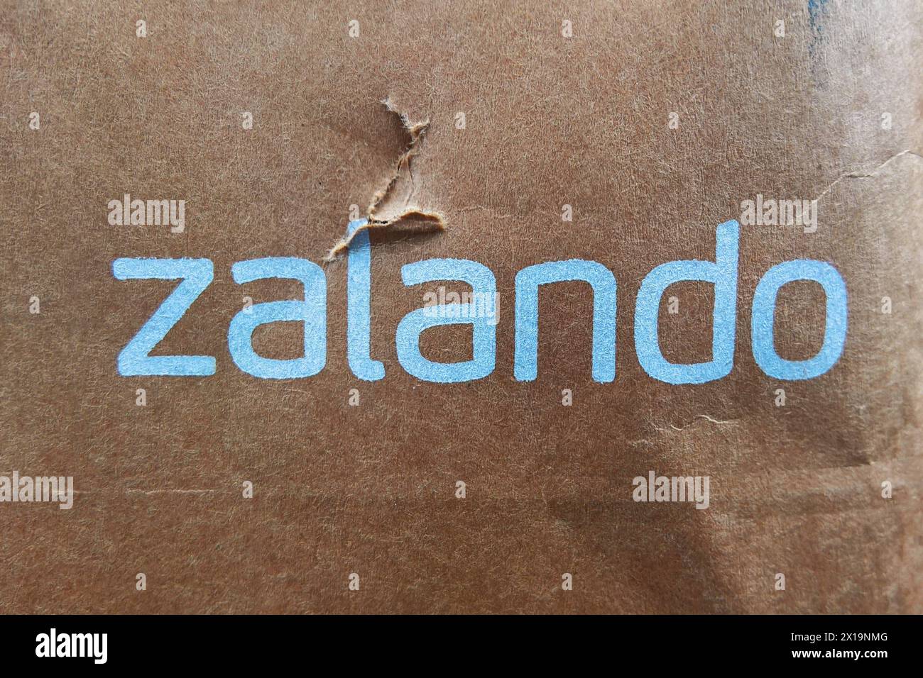 Die Zalando SE mit Sitz in Berlin ist ein börsennotierter deutscher Online-Versandhändler für Schuhe, Kleidung, Kosmetik und Accessoires. Das Unternehmen wurde 2008 von David Schneider und Robert Gentz gegründet und hat mehr als 50 Millionen aktive Kunden in 25 europäischen Märkten. Zalando ist in mehreren Geschäftsfeldern tätig, vom Internet-Shop über Eigenmarken, stationären Outlets in zwölf deutschen Städten. Foto: Zalando-Schriftzug auf einem Paket *** die Zalando SE mit Sitz in Berlin ist ein börsennotiertes deutsches Online-Versandunternehmen für Schuhe, Bekleidung, Kosmetik und Accessoires Stockfoto