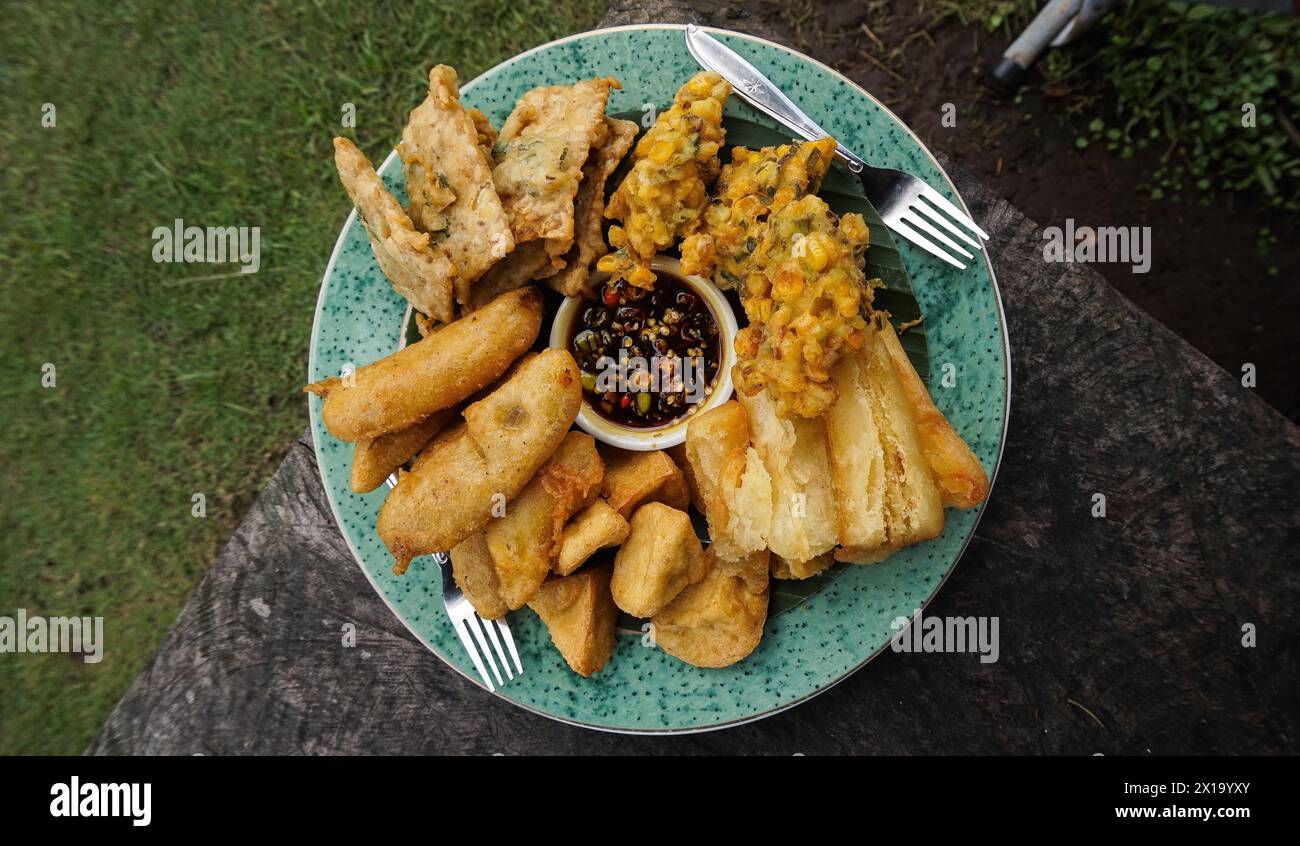 Verschiedene frittierte Speisen werden auf Tellern serviert, die in Indonesien berühmt sind, wie Maisbäckwan, Mendoan, gebratene Banane, gebratener Maniok und gebratener Tofu Stockfoto