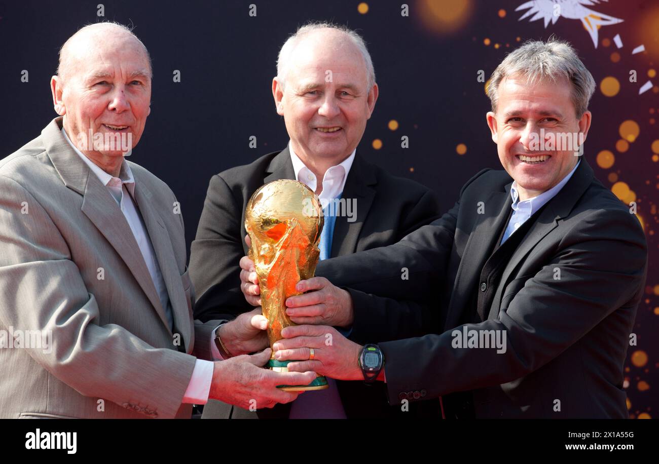 Berlin, Deutschland. März 2014. Die ehemaligen Fußballnationalspieler und Weltmeister Horst Eckel (1954), Bernd Hölzenbein (1974) und Pierre Littbarski (1990) präsentieren am 29.03.2014 die ursprüngliche Trophäe der FIFA Fussball-Weltmeisterschaft am Flughafen Berlin-Tegel. Hölzenbein starb im Alter von 78 Jahren. Quelle: Picture Alliance/dpa/Alamy Live News Stockfoto